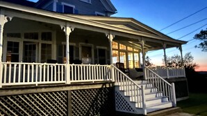 A two-story house with a porch and a staircase leading to the entrance. - Beautiful Roomy Beach House...See and Hear the Ocean Waves (Wells)