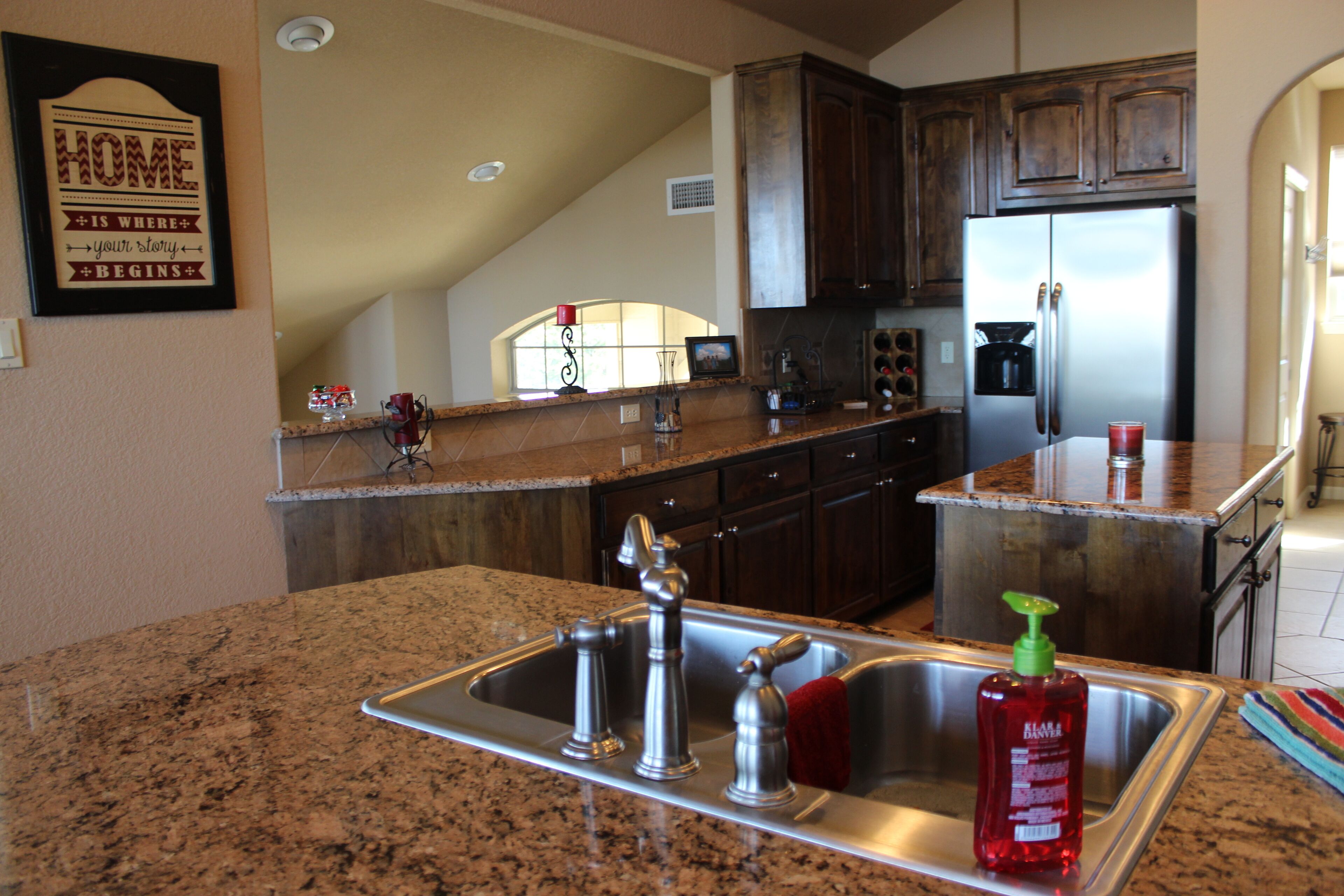 A kitchen with granite countertops, stainless steel appliances, and wooden cabinets.
