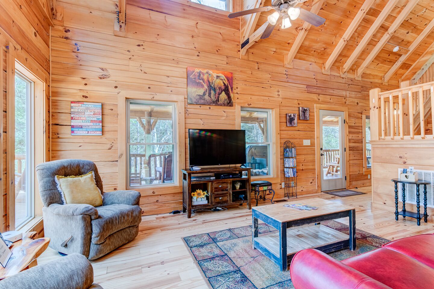 L’intérieur chaleureux d’un chalet, avec un décor en bois, un téléviseur et une cheminée.