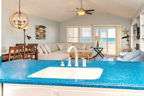 A kitchen with a blue speckled countertop, a sink, and a ceiling fan. - Feels Like Home-3 BR Oceanfront Duplex; Covered Porches (Topsail Beach)