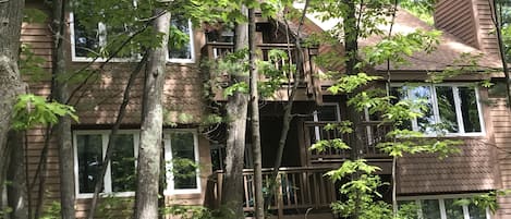 Ein mehrstöckiges Holzhaus, umgeben von Bäumen.