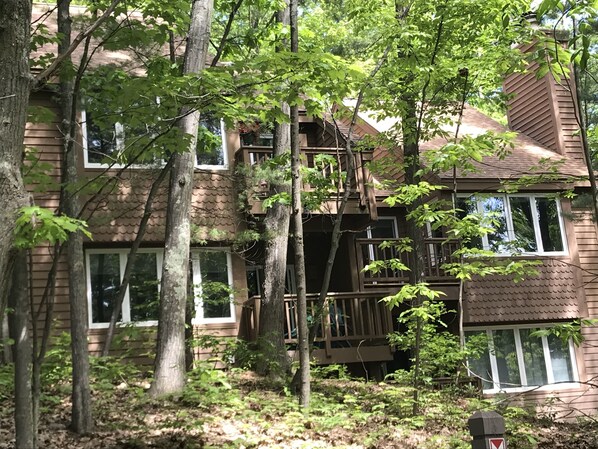 A multi-story wooden house surrounded by trees. -  Chic and Comfortable - Openings:  Aug 22 & 23 (Glen Arbor)
