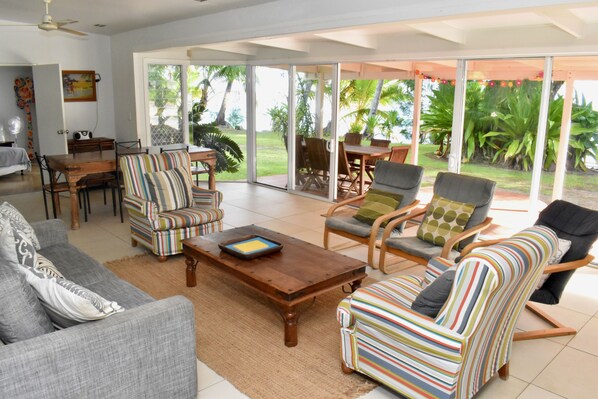 A spacious living room with a sofa, striped armchairs, and a coffee table.