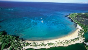 An aerial view of a tropical beach with clear turquoise waters, a sandy shore, and lush greenery. - Quiet Top-floor Penthouse with Golf Course views, 2BR/2BA+Loft, Sleeps 6 (Puako)
