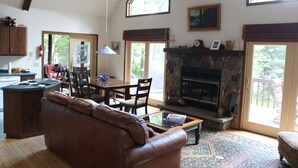 A spacious living room with a fireplace, a dining area, and a kitchen.