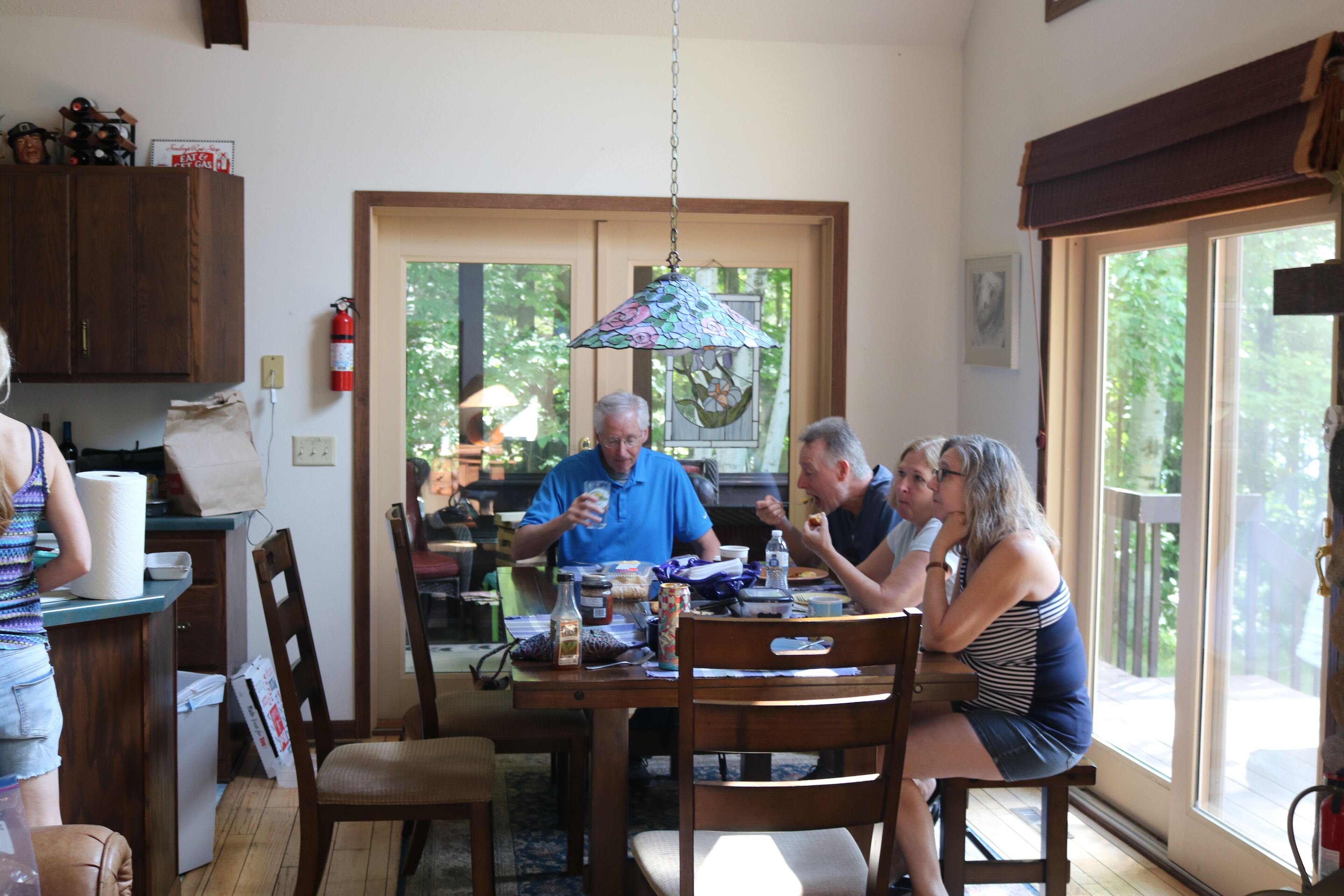 Un espace repas comprenant une table, des chaises et un luminaire suspendu.