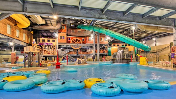 Un parc aquatique intérieur doté de nombreux toboggans, de bouées gonflables et d’un grand espace piscine.