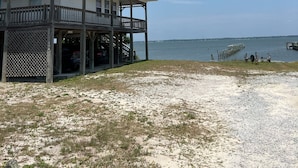 Une propriété de deux étages située en bord de mer, dotée d’un balcon, d’une véranda et offrant une vue sur l’océan.