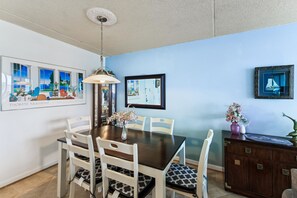 A dining area with a table, chairs, a vase of flowers, and artwork on the walls. - XPLORIE ACTIVITIES & LINENS INCLUDED*! ! QUAY 2BR/2BA Condo with Ocean & Bay Views! (Ocean City)