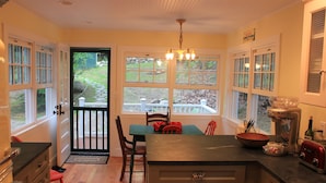 A kitchen with a dining table, chairs, and a coffee maker.