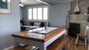 Una cocina con una isla de madera, una chimenea y una zona de comedor con una mesa y sillas.