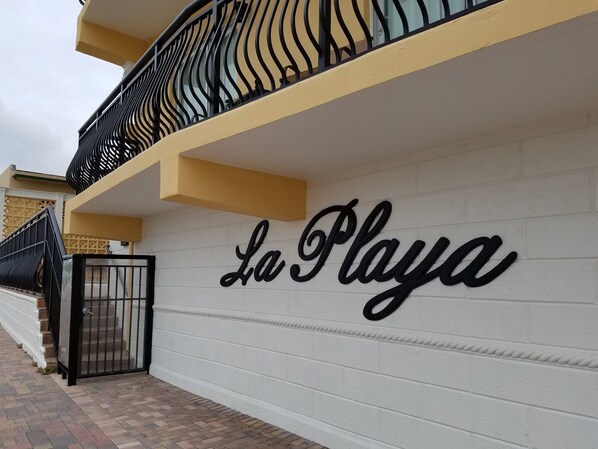 A white wall with the words "La Playa" in a cursive font. - “La Playa” – Stunning Beachfront Condo Directly on the Broadwalk & Ocean (Hollywood)