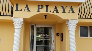 Indgangen til La Playa Condominium Association, med en glasdør og et skilt, der angiver privat bolig.