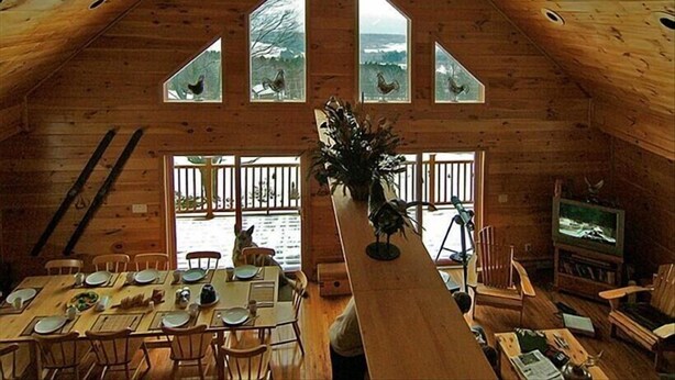 A wooden cabin with a dining area, a large window, and a television. - Mountain retreat near Hunter/Windham Mountain (Prattsville)