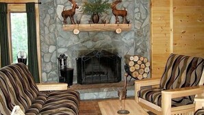 A cozy living room with a stone fireplace, two sofas, and a wooden coffee table. - Mountain retreat near Hunter/Windham Mountain (Prattsville)