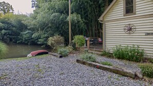 A cabin with a deck overlooking a lake, surrounded by dense forest. - Beautiful Waterside Cabin (2), Great Location, View, 8 Min To Downtown, Biltmore (Asheville)