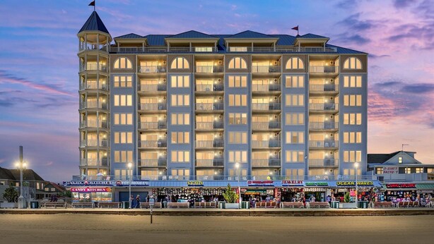 Un hôtel à plusieurs étages doté d’une cour intérieure, avec des balcons à chaque étage et une variété de boutiques au rez-de-chaussée.