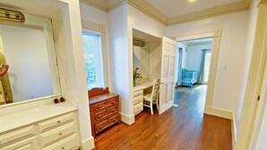 A spacious room with hardwood flooring, a large mirror, a wooden dresser, and a desk with drawers. - Stunning House with Private Pool and Hot Tub on Rural Estate (Castleton)