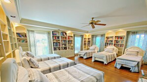 A bedroom with four beds, a ceiling fan, and bookshelves filled with books. - Stunning House with Private Pool and Hot Tub on Rural Estate (Castleton)