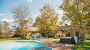 A swimming pool with a hot tub, surrounded by a brick deck and a lawn. - Stunning House with Private Pool and Hot Tub on Rural Estate (Castleton)