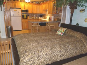 Relax in this cozy retreat with a comfortable bed, kitchenette, and tropical decor.