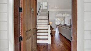 A wooden staircase leading to a living area with a sofa and a lamp. - Heated Pool Access | 5*Clean | Flex Cancelation (Savannah)