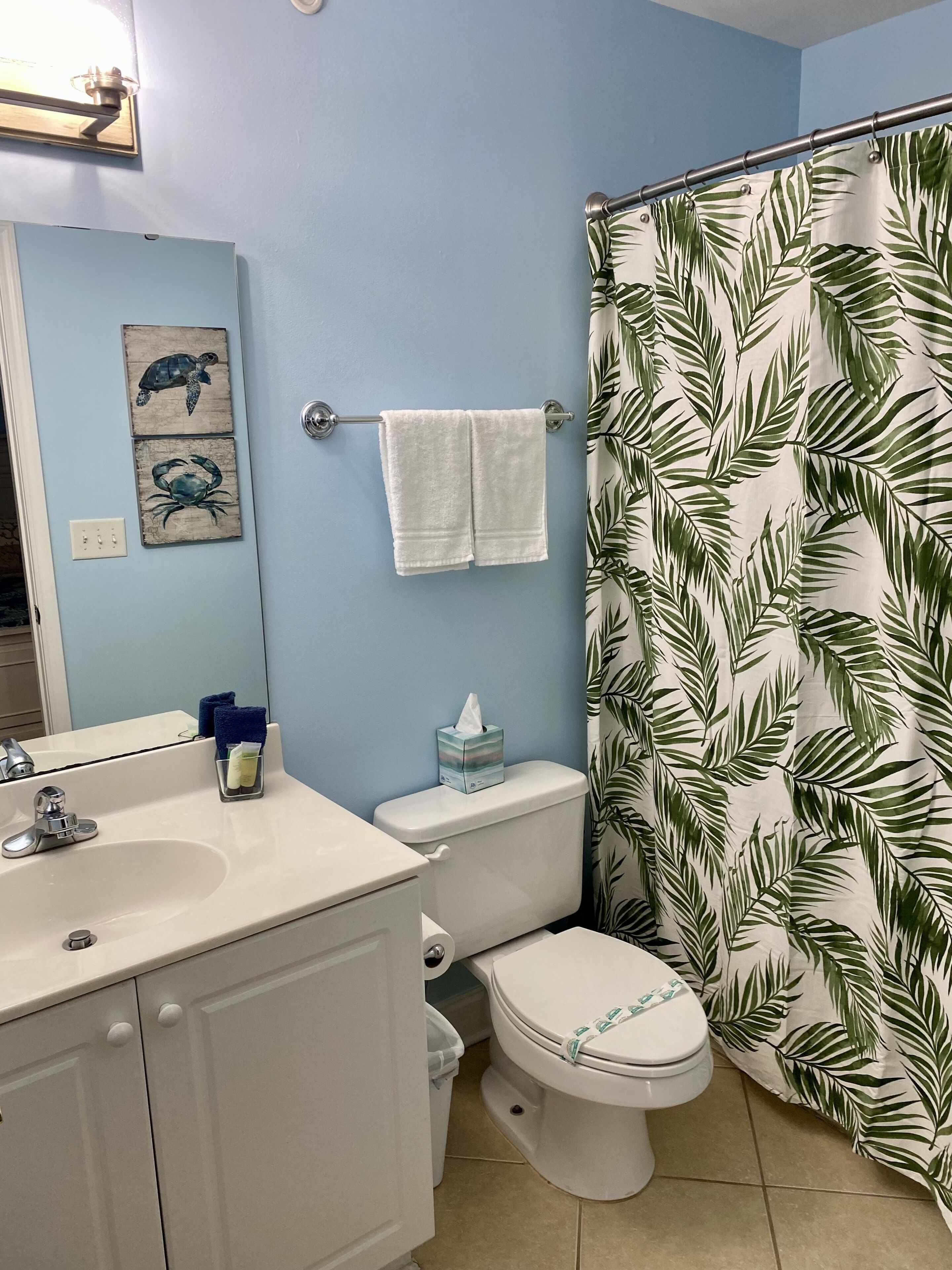 A bathroom with a toilet, sink, and shower curtain.