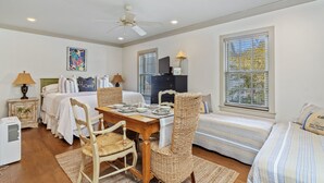 A bedroom with a bed, bedside tables, a desk, and a window. - Charming Carriage House located in Rosemary Beach ~ Pet Friendly (Rosemary Beach)