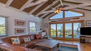 Amplia sala de estar con un sofá de cuero, una mesa de centro de madera y un ventanal con vistas al exterior.