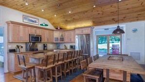 Una cocina amplia con armarios de madera, electrodomésticos de acero inoxidable y una isla grande con taburetes de bar.