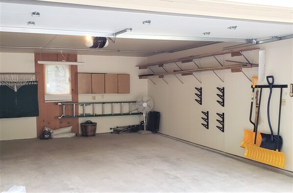 Een garage met een werkbank, gereedschap en een ventilator.