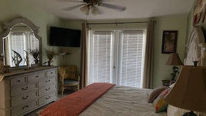 A bedroom with a bed, dresser, chair, and a ceiling fan. - Nader Vacation Rental (Little Torch Key)