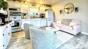 A compact living space with a kitchenette, a sofa, and a coffee table.