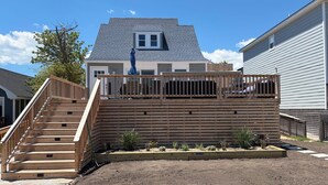 Il s’agit d’une propriété résidentielle dotée d’une terrasse en bois, d’un escalier et d’un jardin clos.