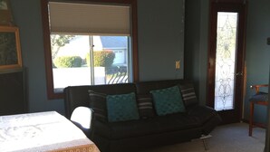 A living room with a sofa, a table with a lace tablecloth, and a ceiling fan.