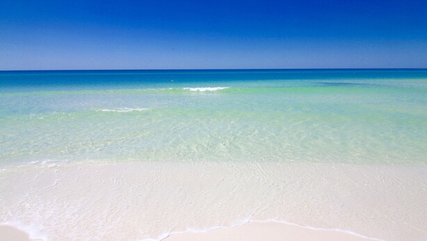 En strand med klart turkis vand og hvidt sand.