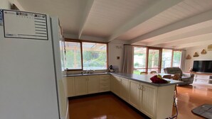 A spacious kitchen with white cabinets, a built-in oven, and a large window. - The Shelter bnb @ Robe SA (Robe)