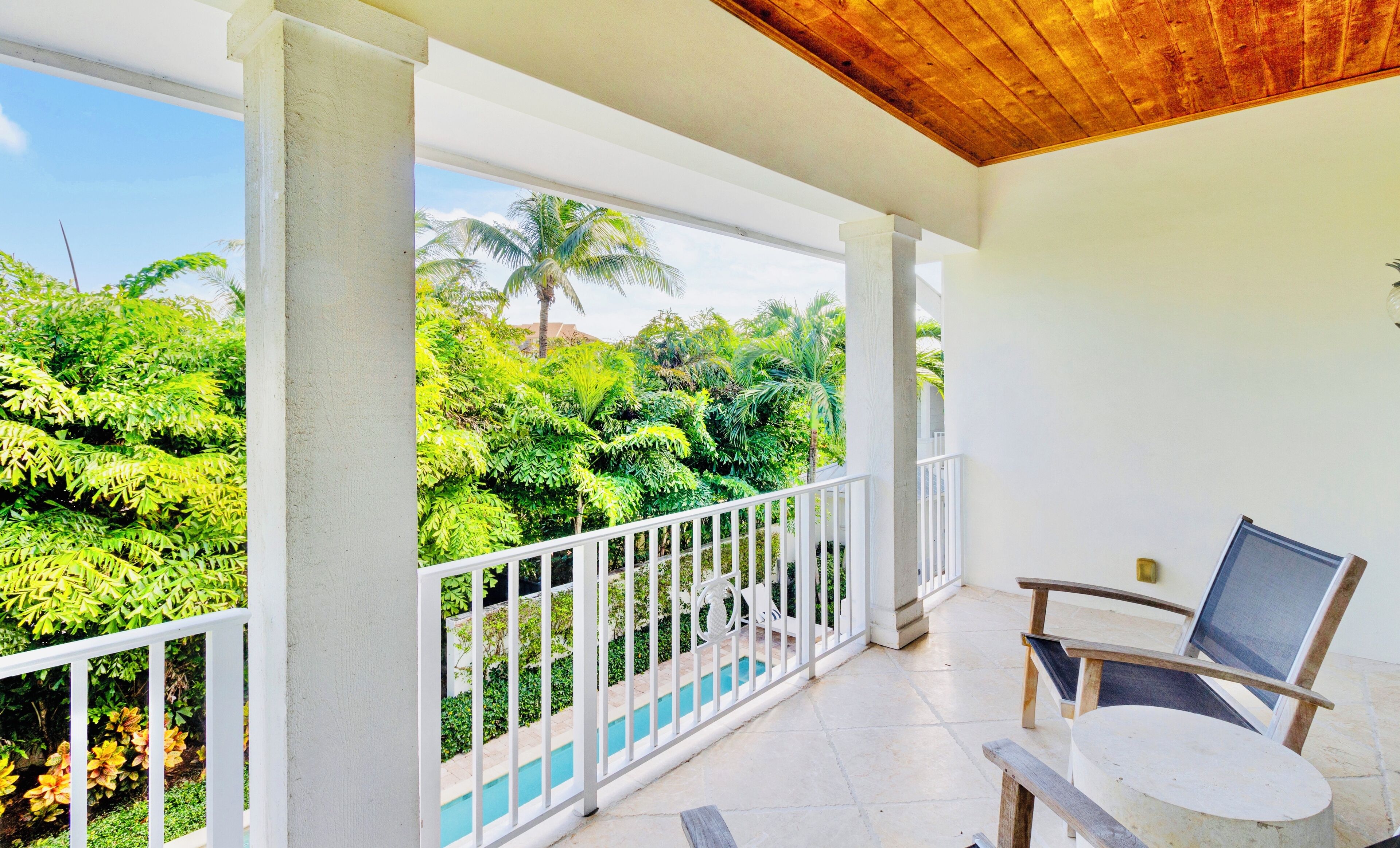 Ein Balkon mit Blick auf üppiges Grün und einen Pool.