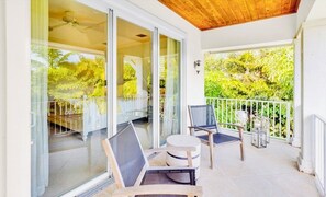 Second-floor primary balcony surrounded by lush tropical greenery. - Luxury Beach Retreat - 200 Steps to Beach - Heated Pool, Spa & Elevator (Jupiter)