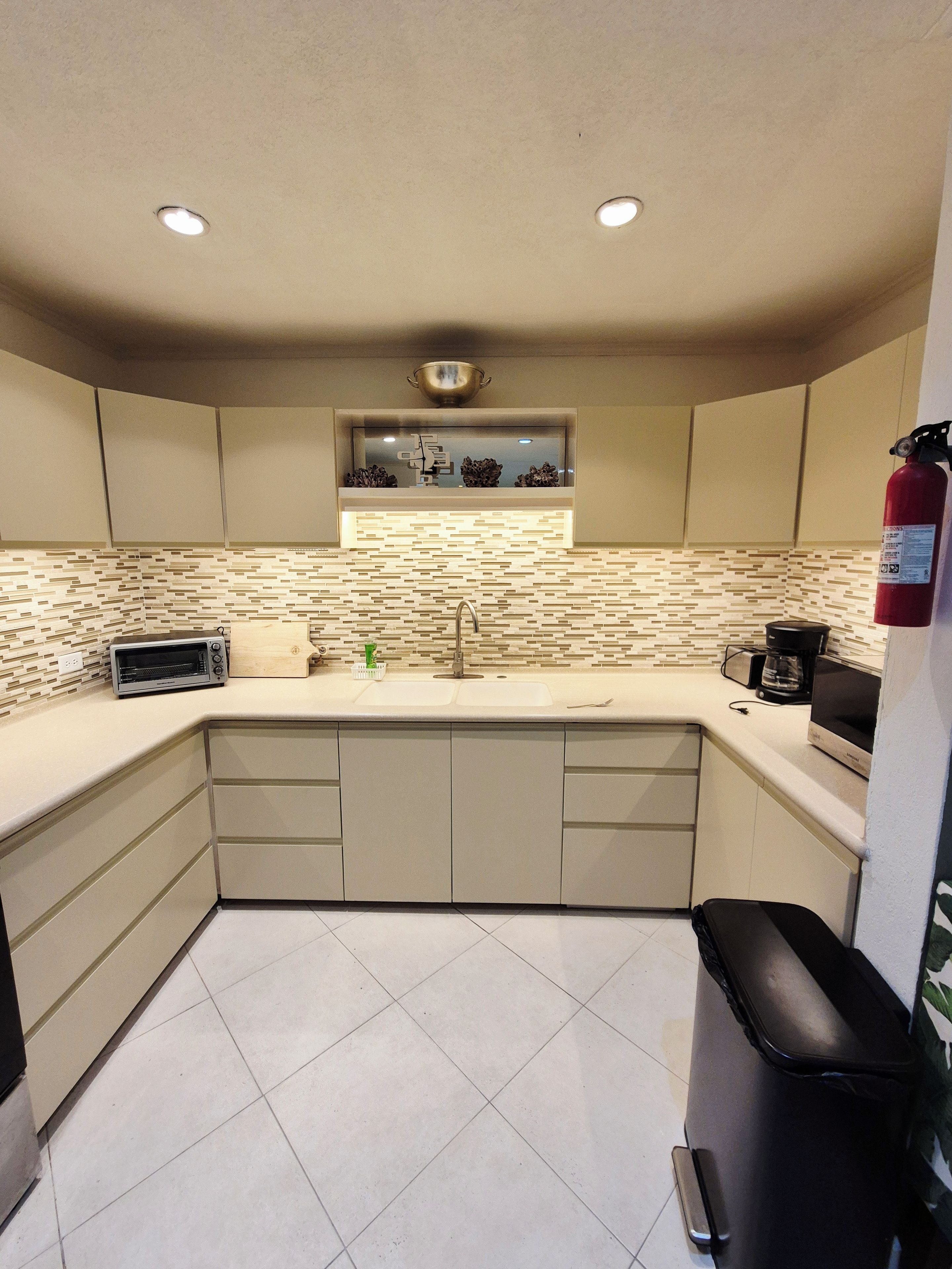 A compact kitchen with a built-in toaster, a sink, and a coffee maker.