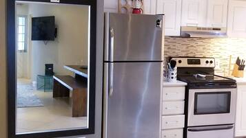 A modern kitchen with a stainless steel refrigerator, a built-in oven, and a microwave.