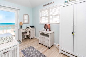 A room with a view of the sea, a white wardrobe, a wicker desk, and a small cabinet with a radio. - Sundog - Spacious 4 BR Oceanfront Home with 2 Sun Decks (North Topsail Beach)