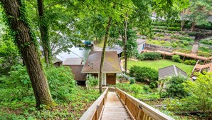 Un escalier en bois mène à une maison d’où l’on a vue sur une rivière et un quai.