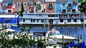 Een pand aan het water met kleurrijke gebouwen, een steiger met boten en uitzicht op het water.