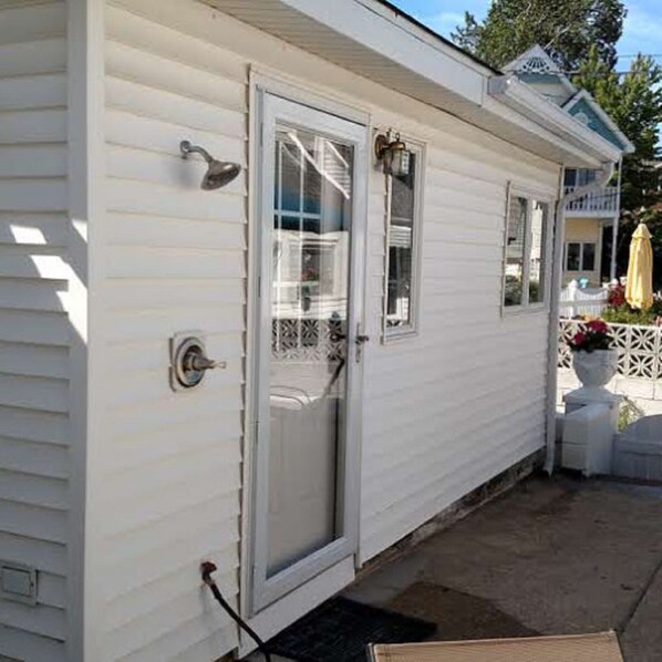 Una casa móvil blanca con puerta principal, un pequeño porche y una ventana.