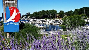Een jachthaven met aangemeerde boten, omgeven door groen en een bord dat de South Haven Riverfront aangeeft.