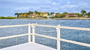 Vista al agua con un muelle y casas al fondo.
