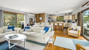Ein modernes Wohnzimmer mit Sofa, Couchtisch und Essbereich.