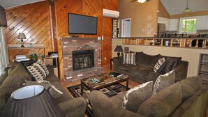 A cozy living room with a fireplace, a sofa set, and a coffee table. - Perfect Getaway In The Poconos! (House #1) HotTub !! Gameroom!! WiFi !! (Albrightsville)