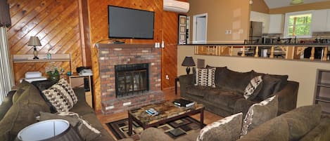 Una sala de estar acogedora con chimenea, un conjunto de sofás y una mesa de centro.